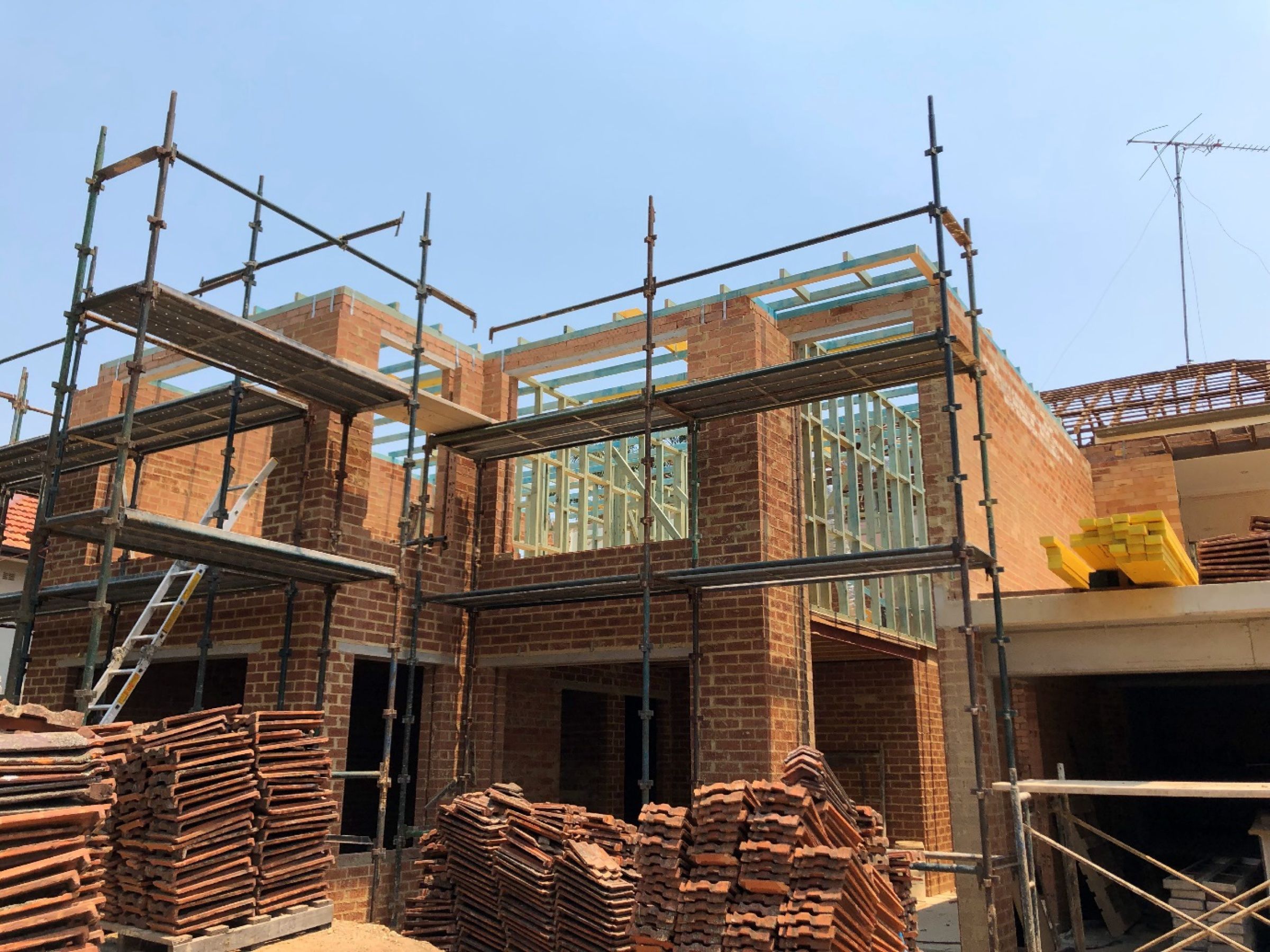 Brick and timber-framed extension under construction with scaffolding